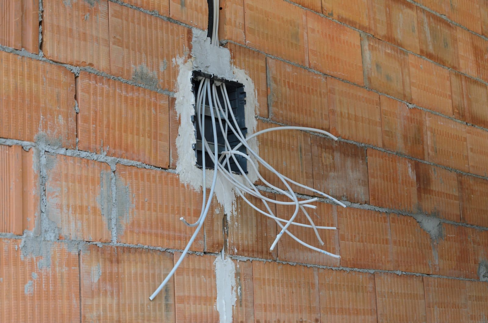 Device box and conductors in a brick wall.